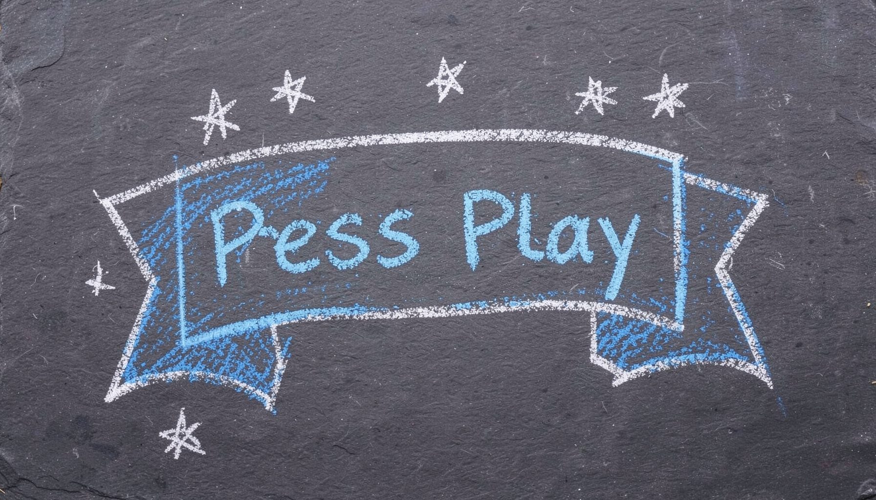 Chalk sketch of a banner reading Press Play surrounded by soft blue music notes on a chalkboard